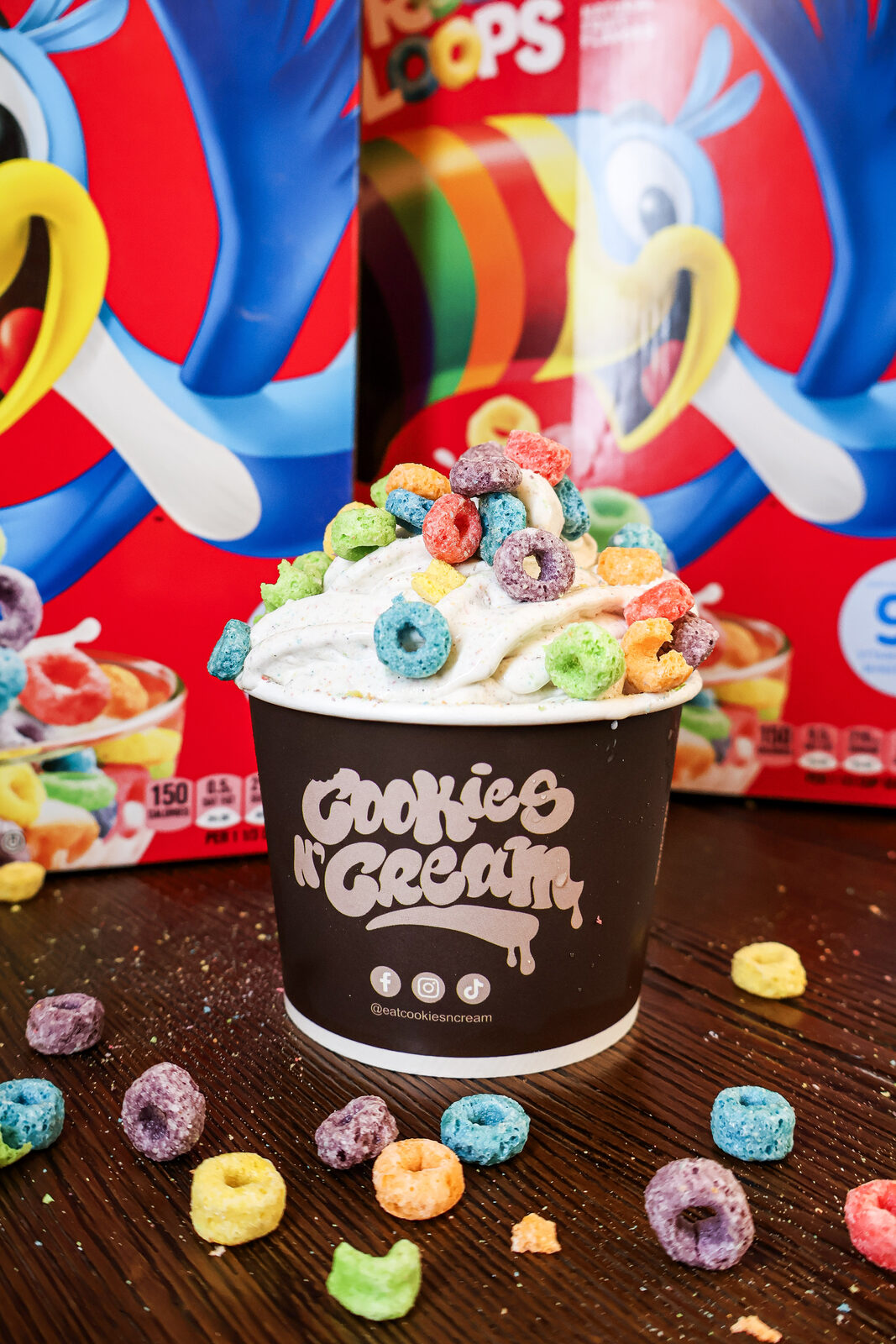 Cookies N' Cream cereal ice cream cup topped with Froot Loops in front of a cereal box